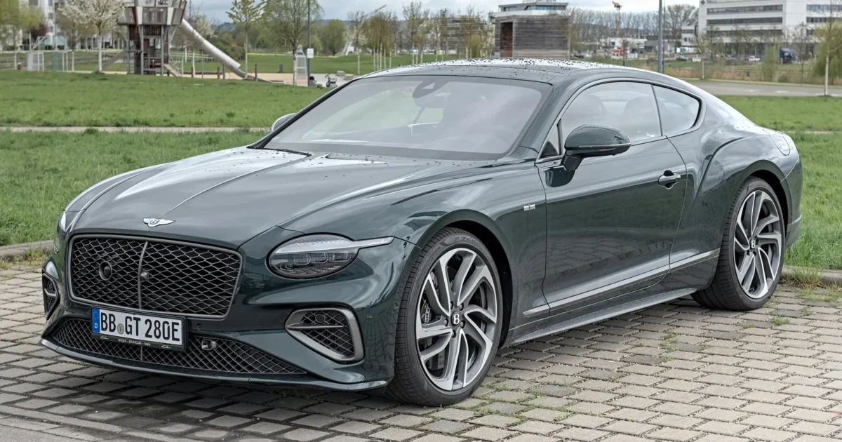 A dark green Bentley Continental GT coupe parked on a paved square
