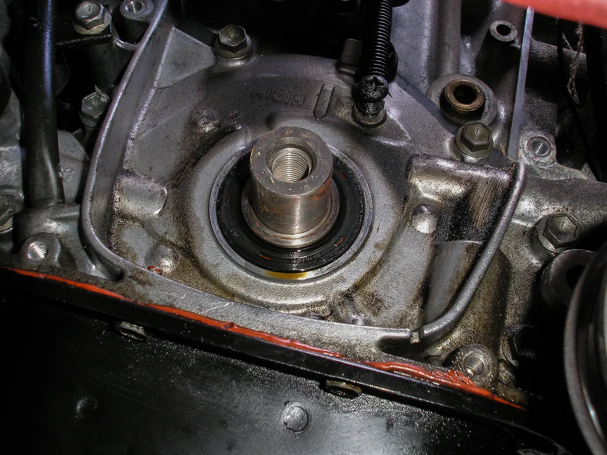 A worn round oil seal around the end of a crankshaft on a small engine