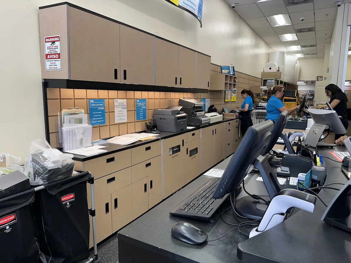 The counter and the work area behind it at a UPS Store, with printers and packing supplies