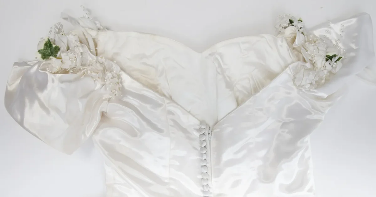The back of a white satin wedding dress with a long row of buttons
