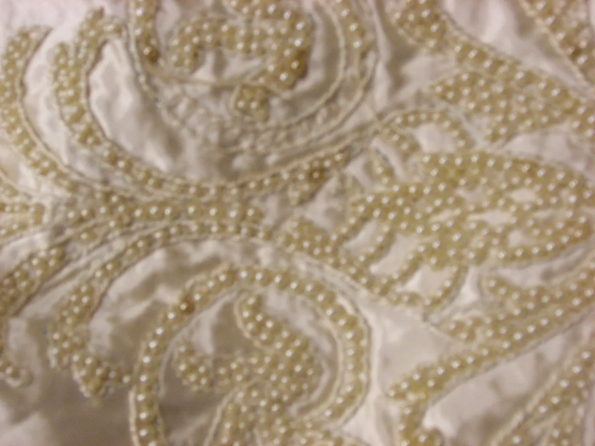 Close-up of pearl beading sewn onto cream satin