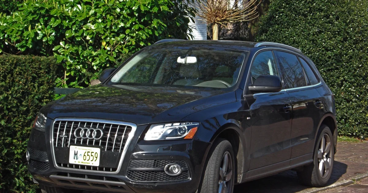 Dark Audi Q5 parked beside a road, viewed from the front corner.