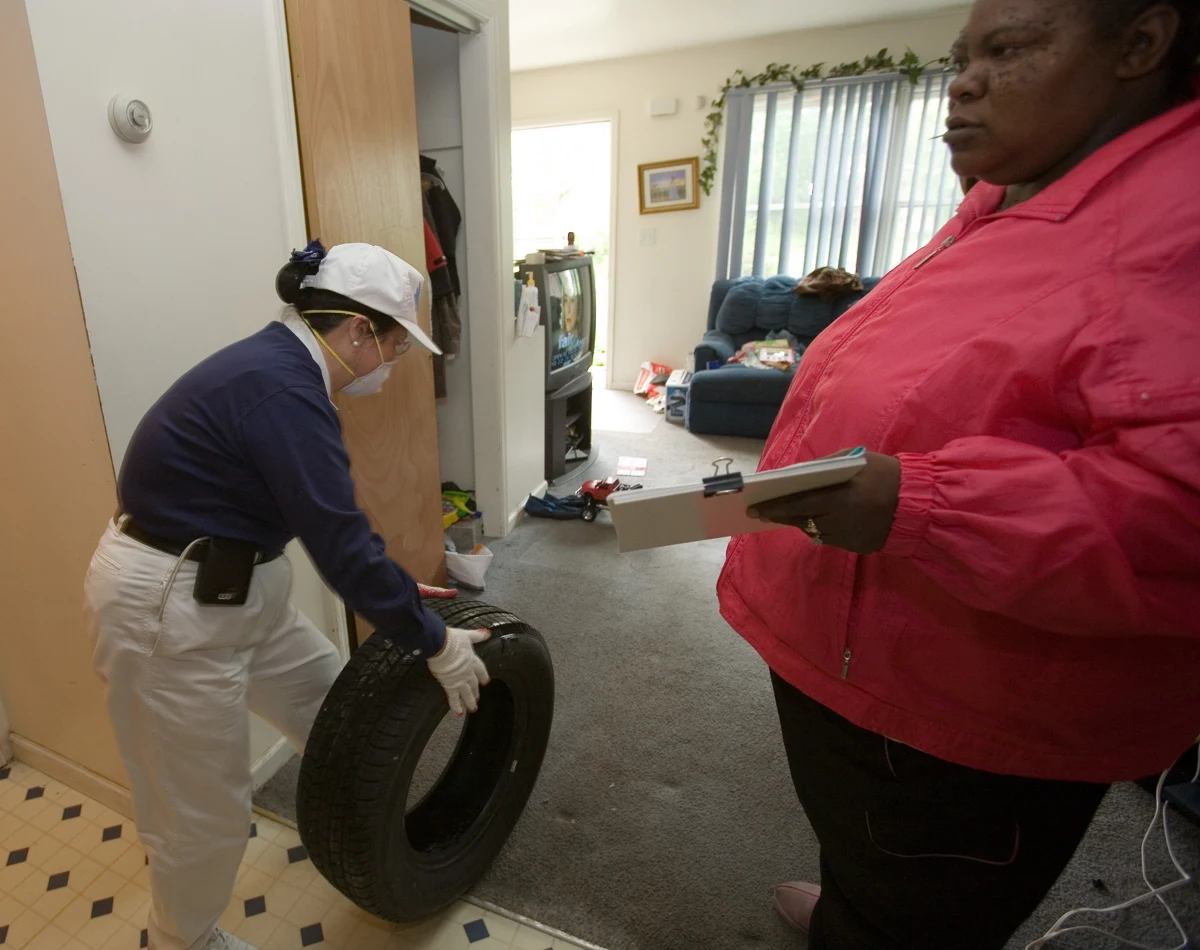 Volunteer helping a resident remove an item from a flood-damaged basement.