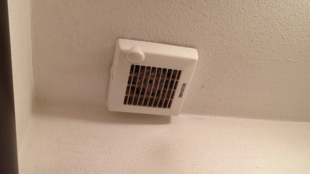 A rectangular bathroom ventilation fan grille.