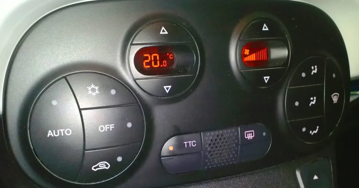 The round heat and air conditioning controls of a Fiat 500 Abarth, with AUTO and OFF buttons and two small red displays