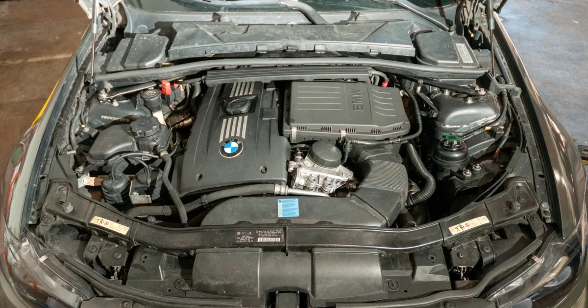 A BMW E90 335i engine bay with the engine cover visible.