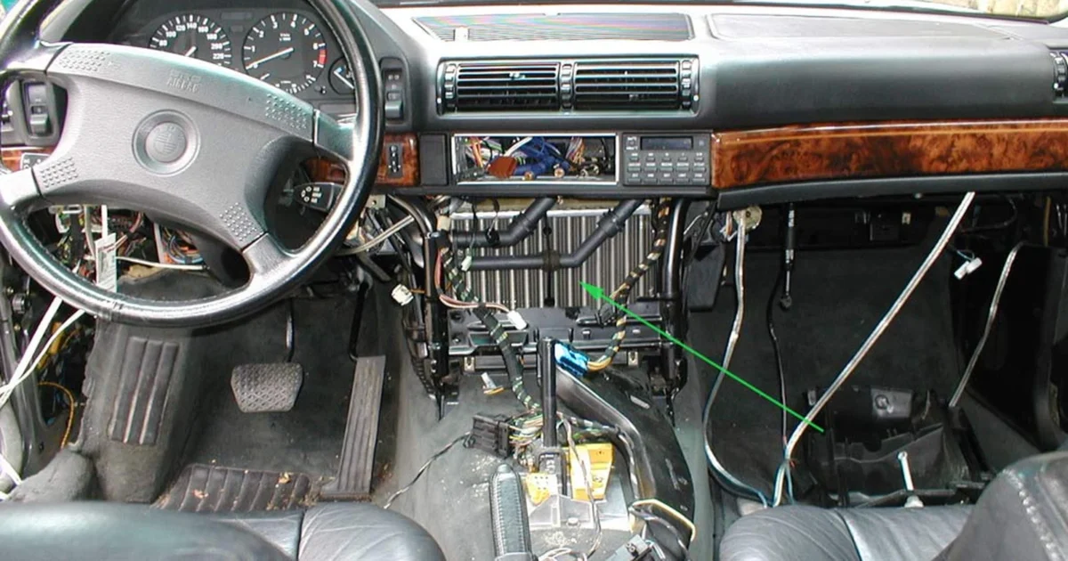 A BMW E32 cabin with center-console trim removed, exposing the heater unit and wiring.