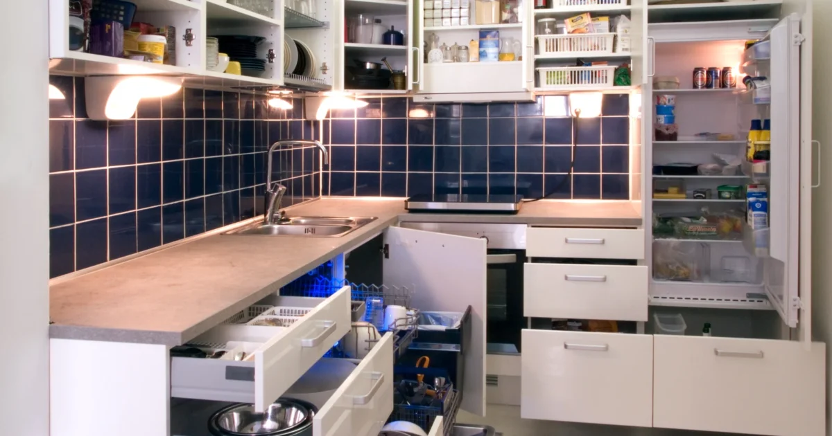 White kitchen with open wall cupboards and extended base drawers showing the cabinet interiors.