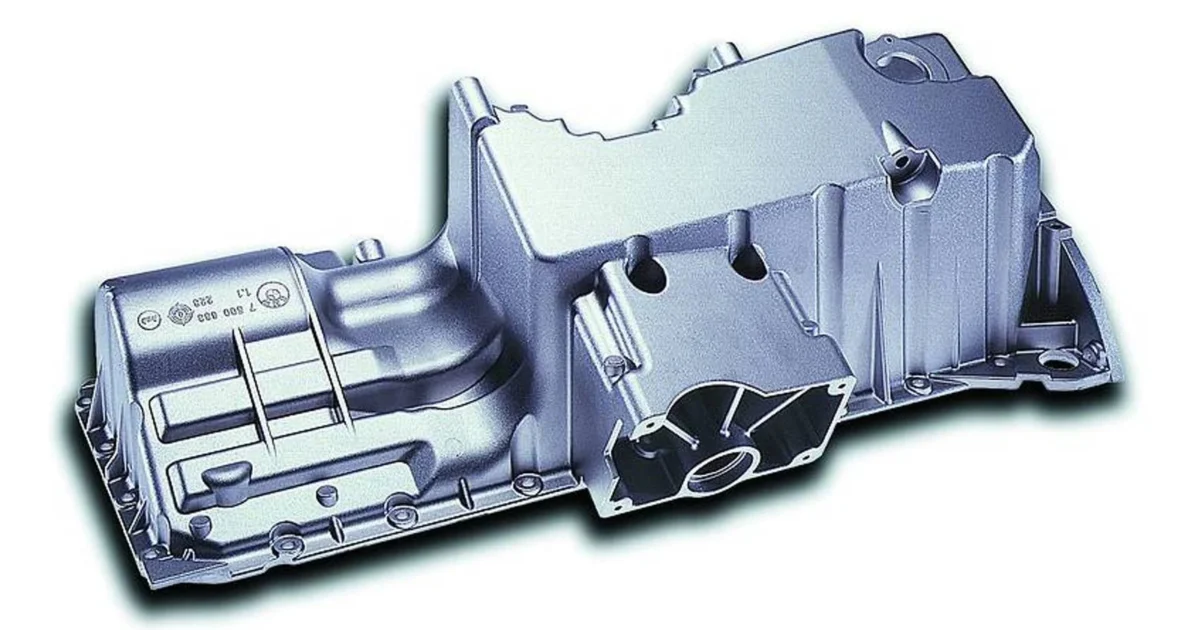 A real cast metal oil pan with its perimeter flange and bolt holes visible.