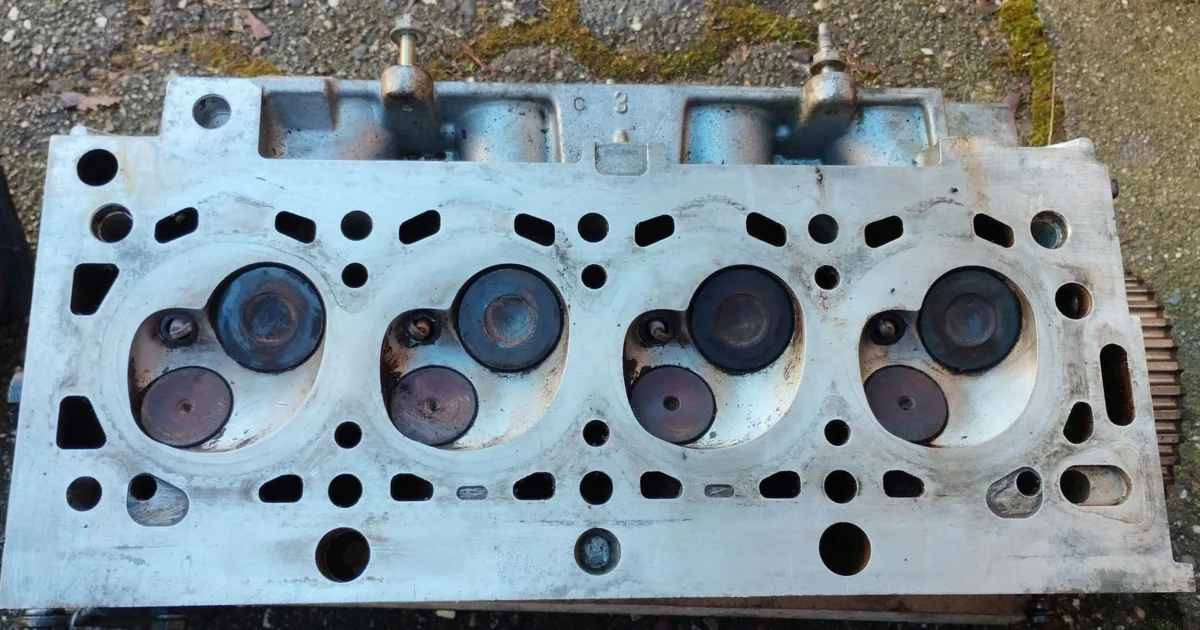 Underside of a removed PSA TU1A cylinder head, showing four combustion chambers, valves and passages.