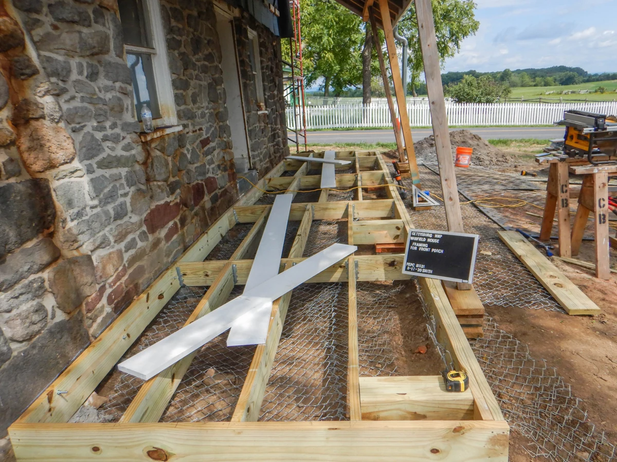 Exposed wood framing beneath a porch during reconstruction.