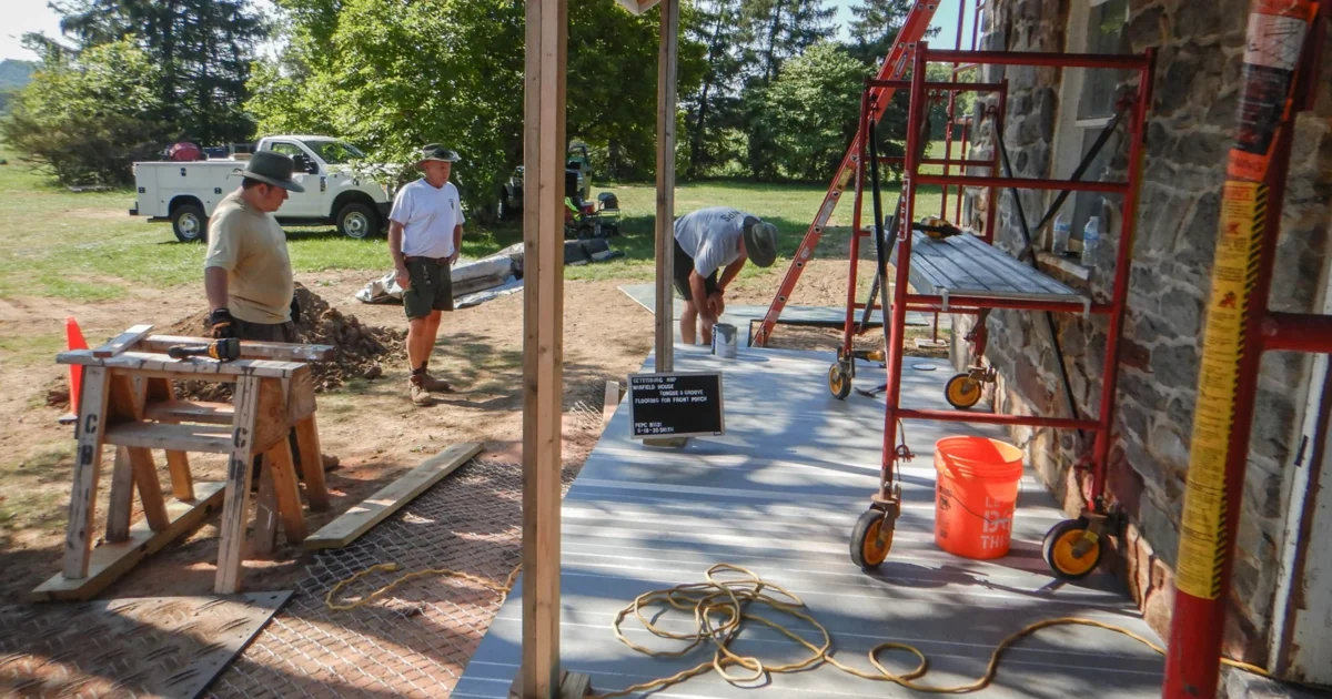 Preservation crew working beside newly installed porch decking.
