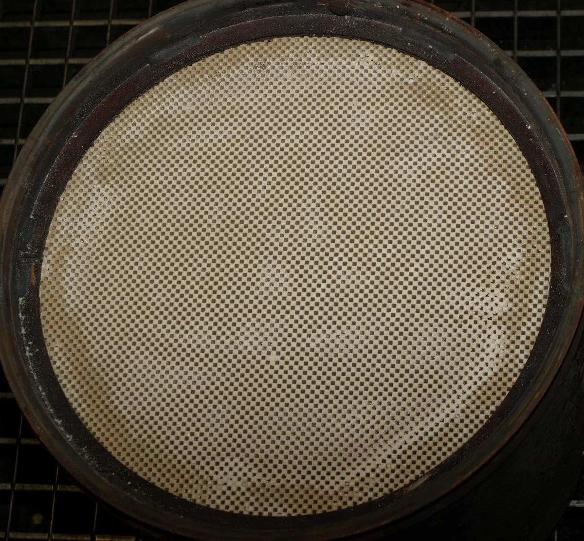 The round face of a cleaned particulate filter, a light honeycomb of tiny square channels in a dark ring