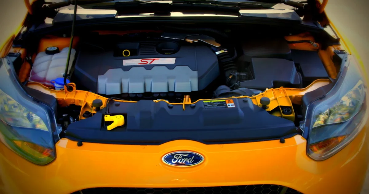 Open engine bay of a 2013 Ford Focus ST, with the EcoBoost engine cover, hoses and intake visible.