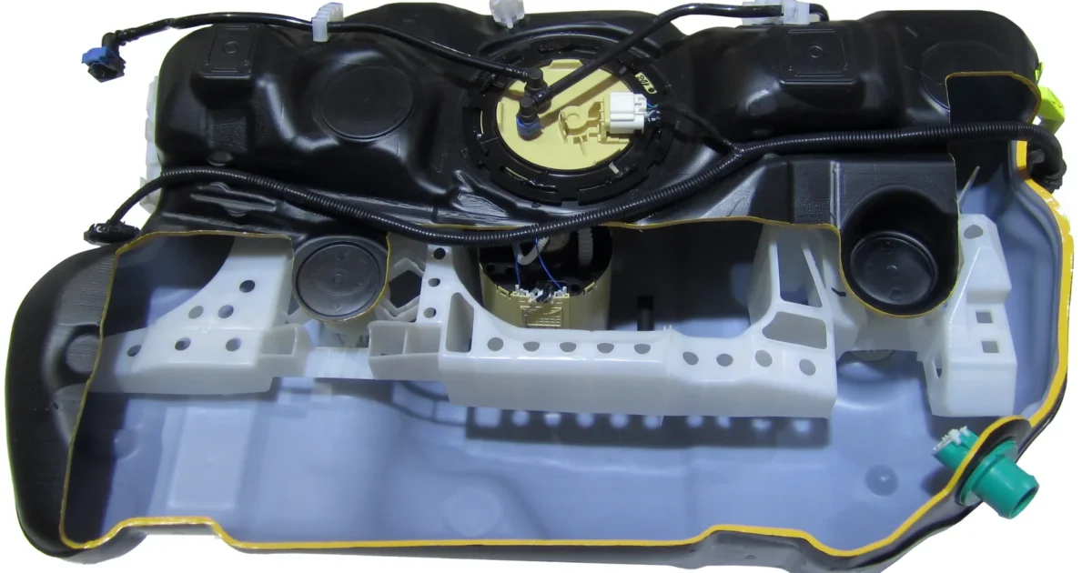 A cutaway automobile fuel tank showing internal components and the top-mounted module.