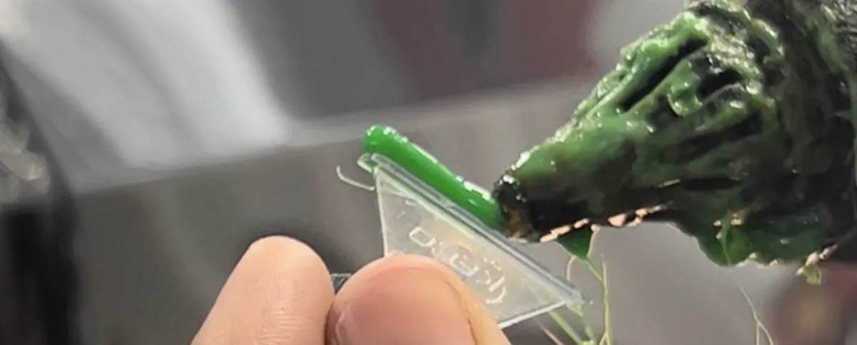 Hot glue going onto a plastic dent repair tab