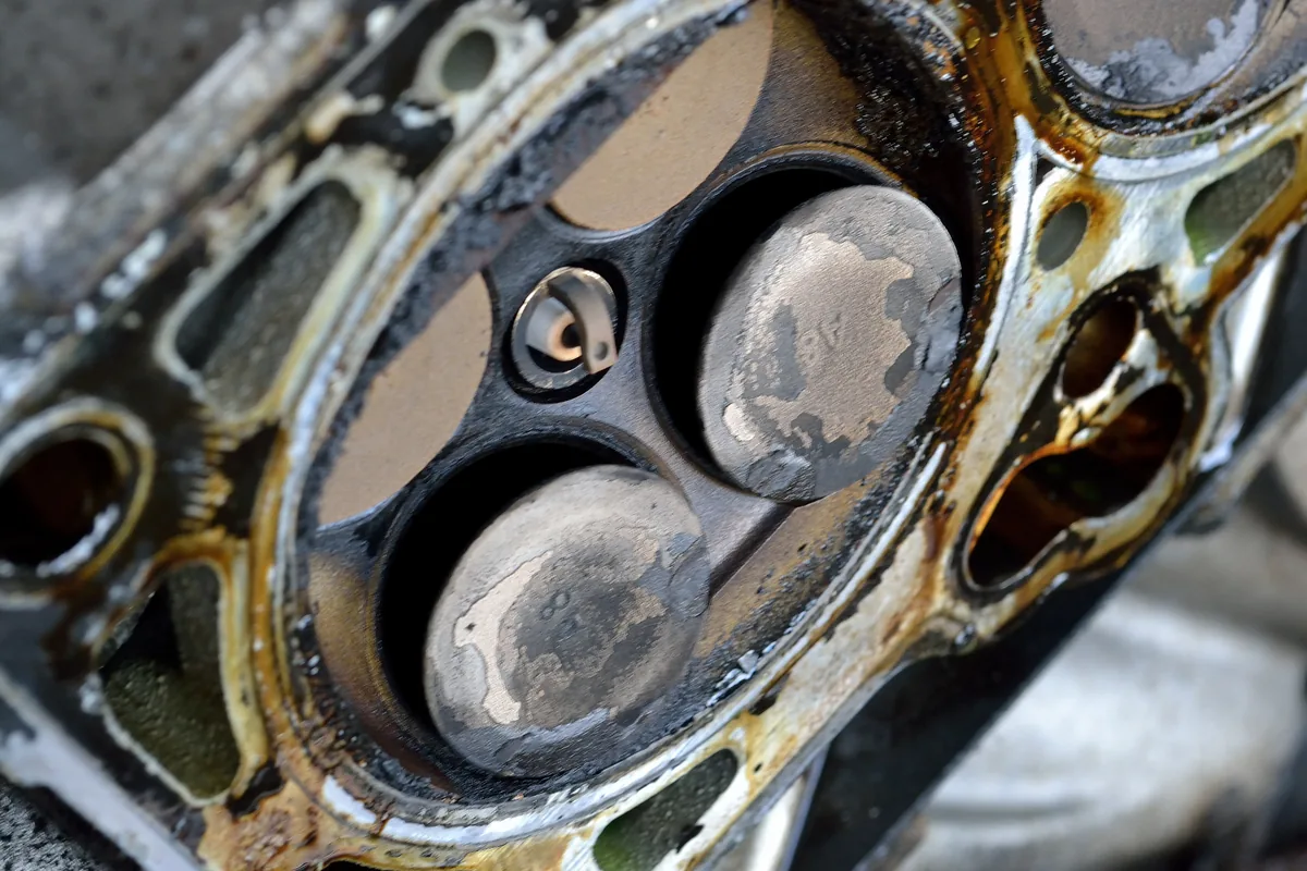 The underside of a cylinder head with two intake valves bent out of their seats
