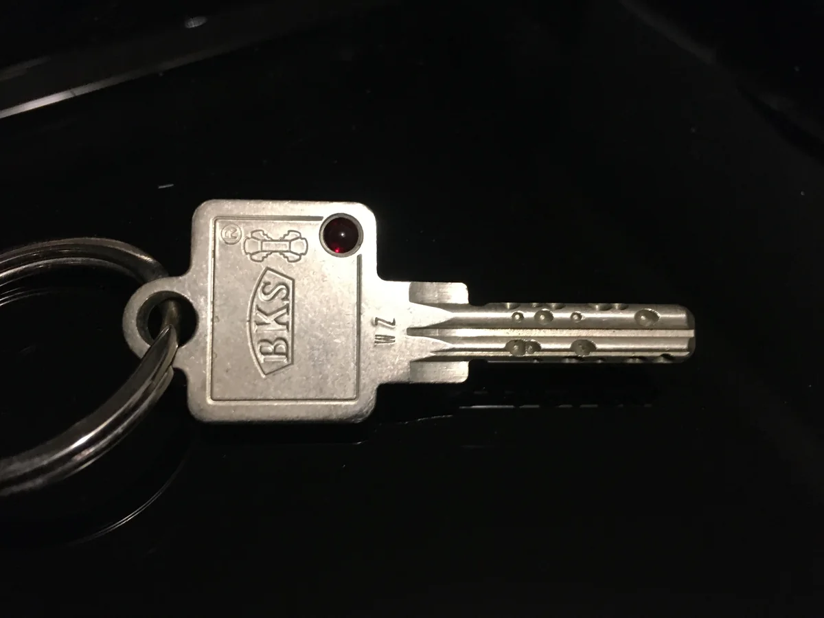 A BKS Janus house key on a metal keyring.
