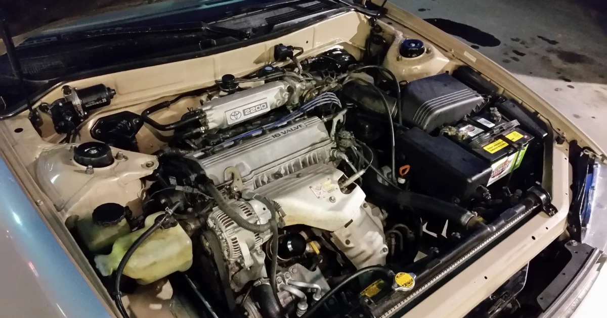Toyota 5S-FE engine in a 1994 Camry LE, with the air filter box, intake hose and throttle area beside the engine.
