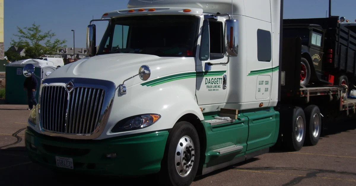 White and green International ProStar tractor parked outdoors.