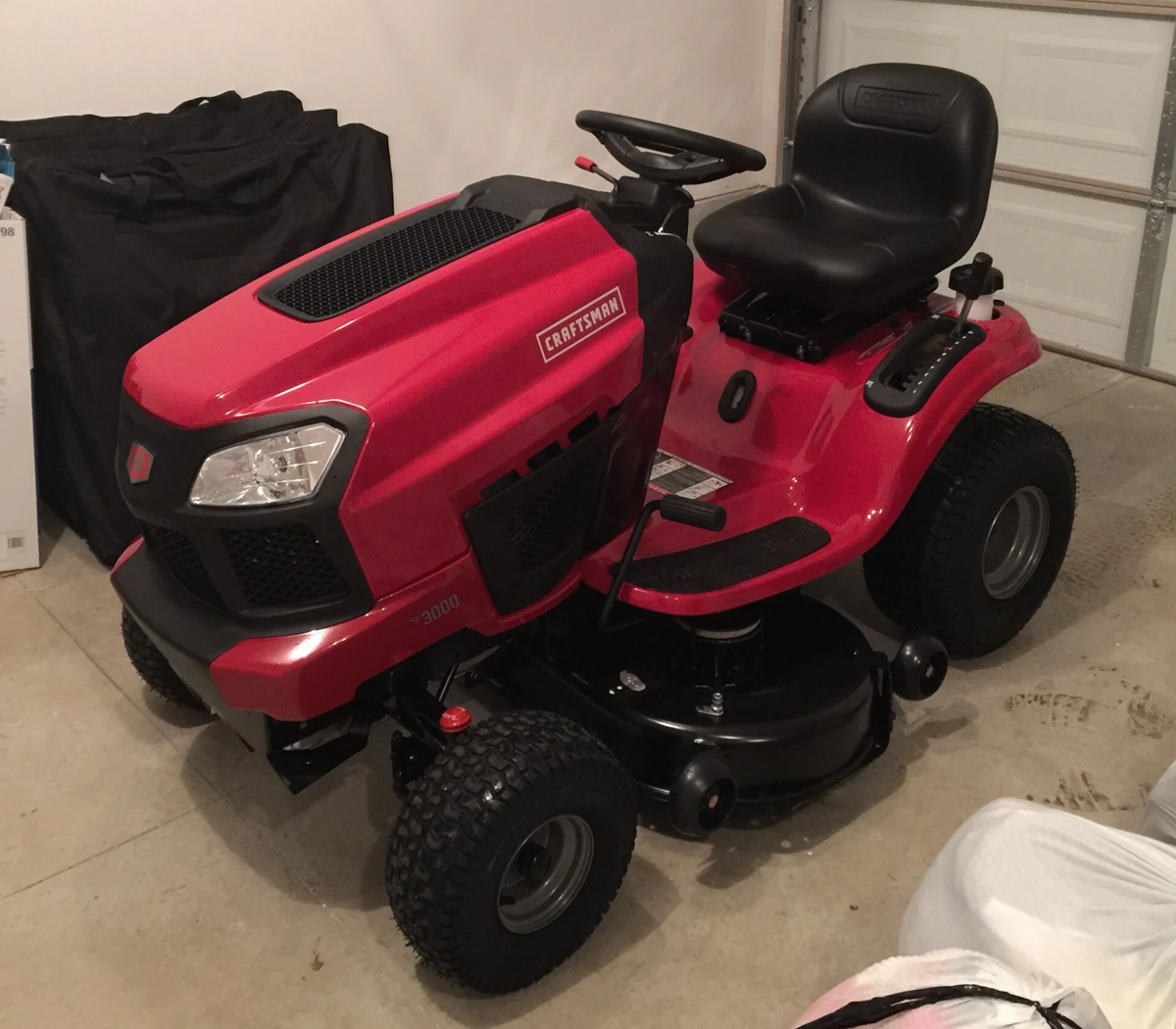 A red riding lawn mower with a cutting deck beneath the seat.