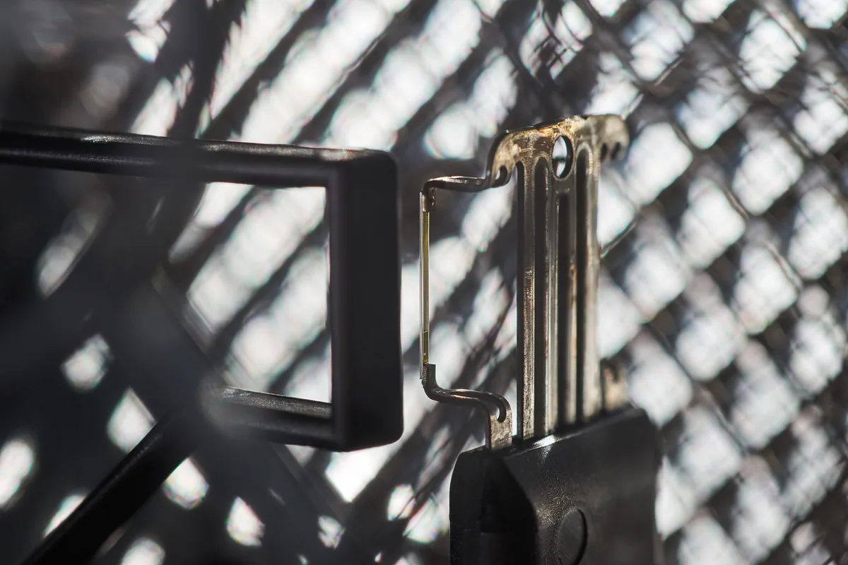 A close view of the thin sensing element of a hot film mass air flow sensor behind its protective mesh
