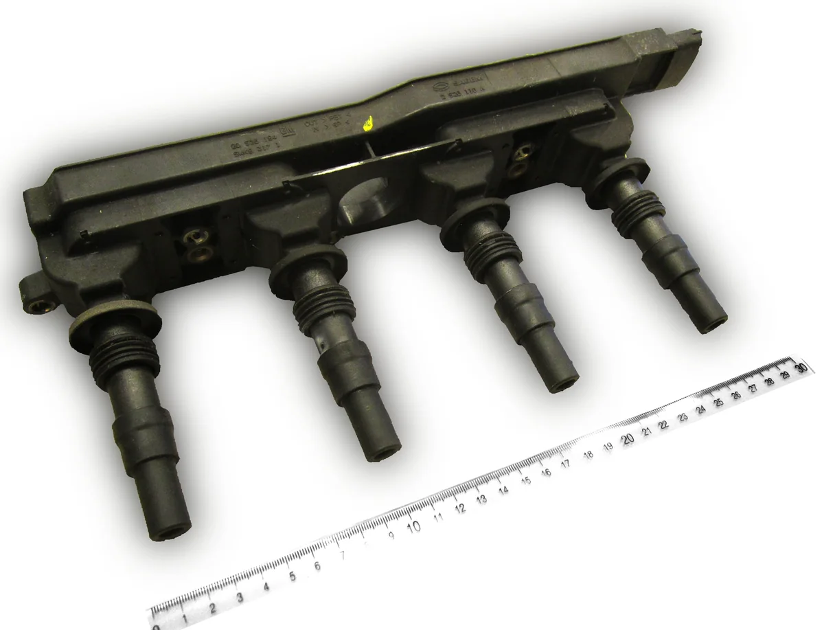 An Opel Z18XE ignition module with four long plug boots and a centimeter ruler.