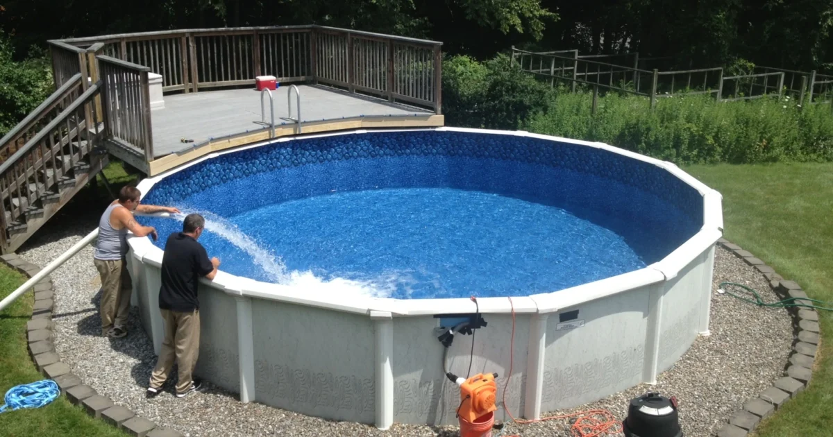 Round above-ground swimming pool with an exposed wall and a raised wooden deck beside it.