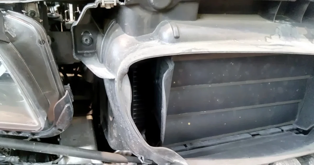 A radiator and its air-control shutter behind the open front bodywork of a car.