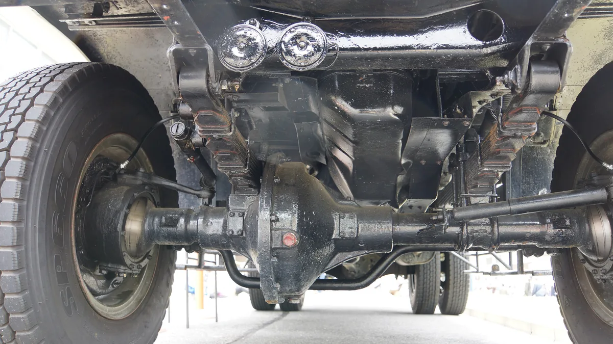 The underside of a truck with the rear axle running between the wheels and the round differential in the middle
