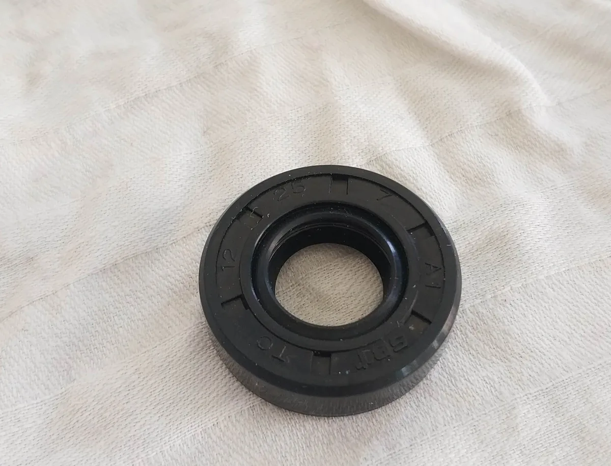 A small black rubber shaft seal lying on a white cloth