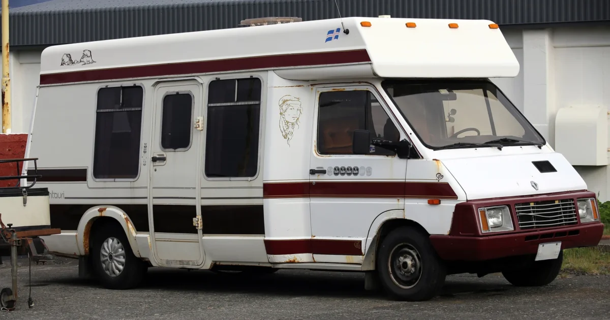 White and red Winnebago Centauri motorhome with a raised roof and rooftop equipment.