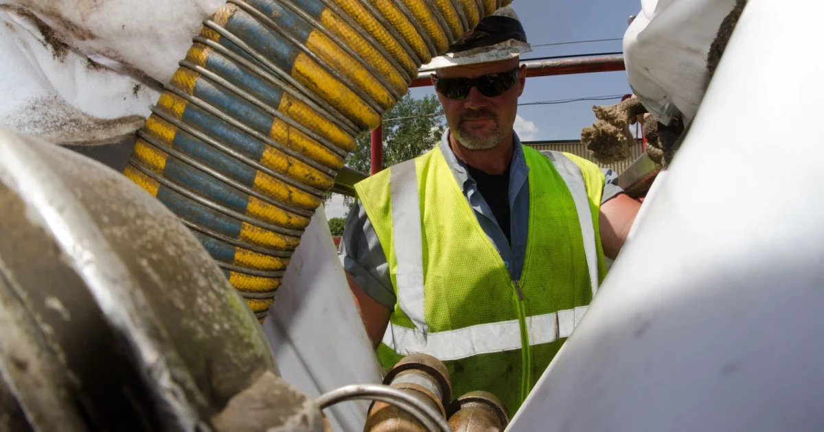 Worker monitoring water flow during a sewer pipe lining project.