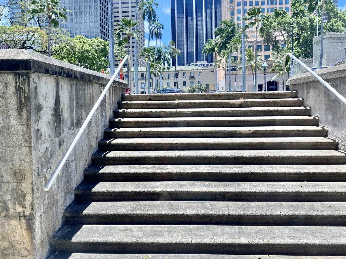 Exterior concrete stairs with handrails beside a building in Honolulu.