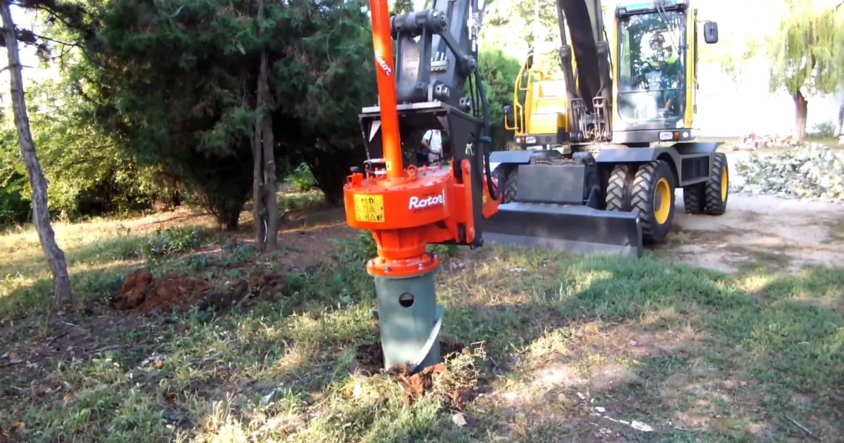 A hydraulic rotor stump-removal attachment mounted on an excavator.