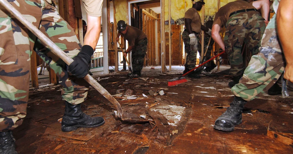 Navy Seabees removing a damaged plywood floor in Waveland, Mississippi.