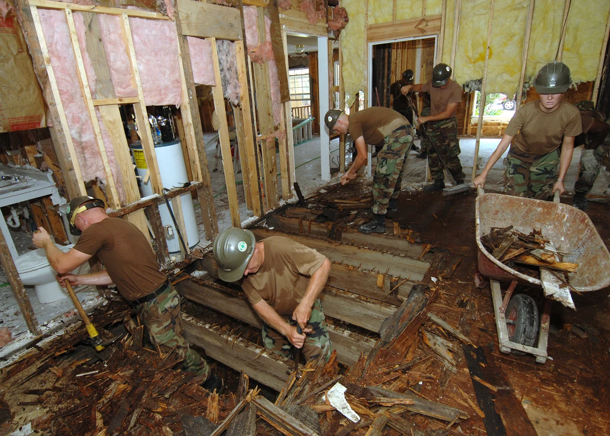 Seabees lift broken plywood during restoration of Hope Haven in 2005.