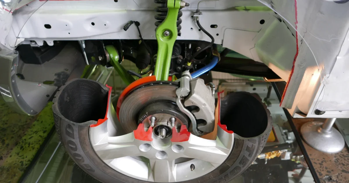 A cutaway Ford Territory display exposing the spring, damper, arms, brake and wheel hub.