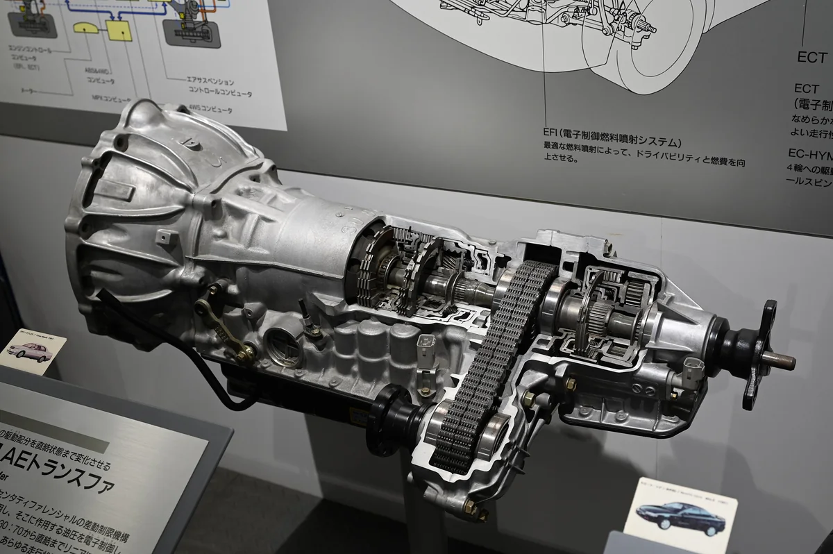 A museum cutaway of a Toyota Crown Majesta transmission and UF1AE transfer assembly, showing its gears and chain.