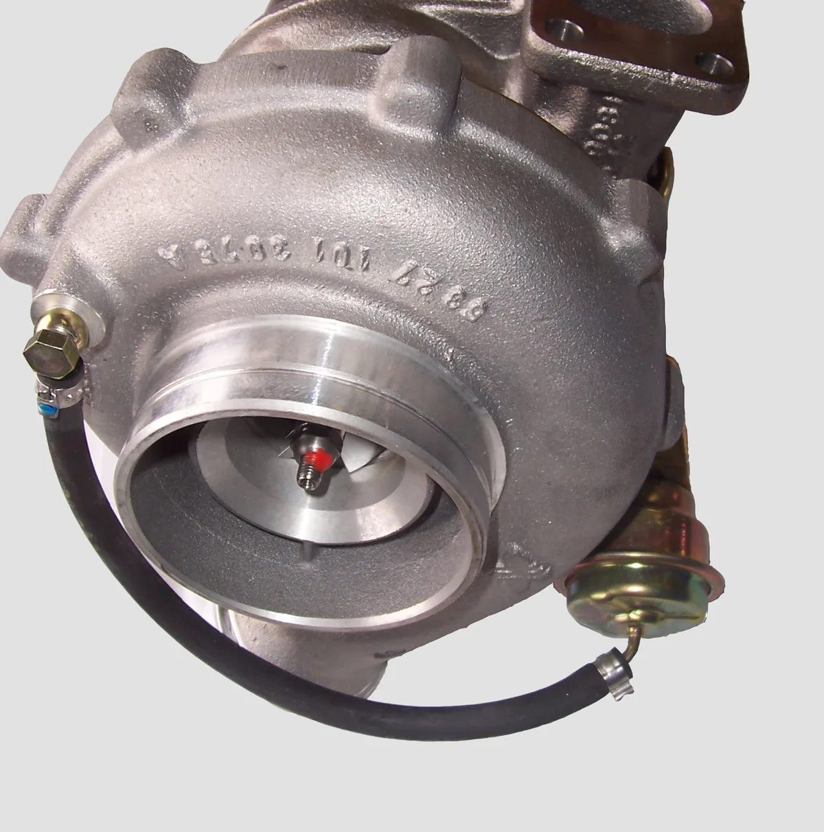 A diesel turbocharger with a round compressor housing and a small wastegate actuator fed by a hose