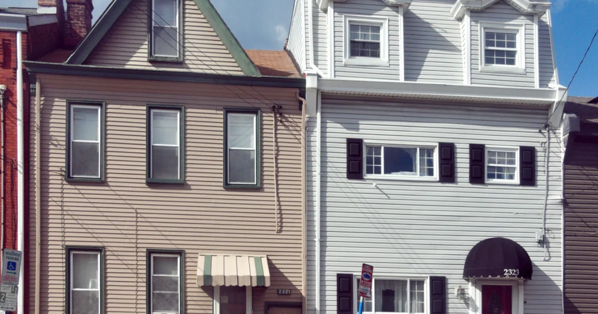 Two Pittsburgh houses with vinyl siding and contrasting trim.