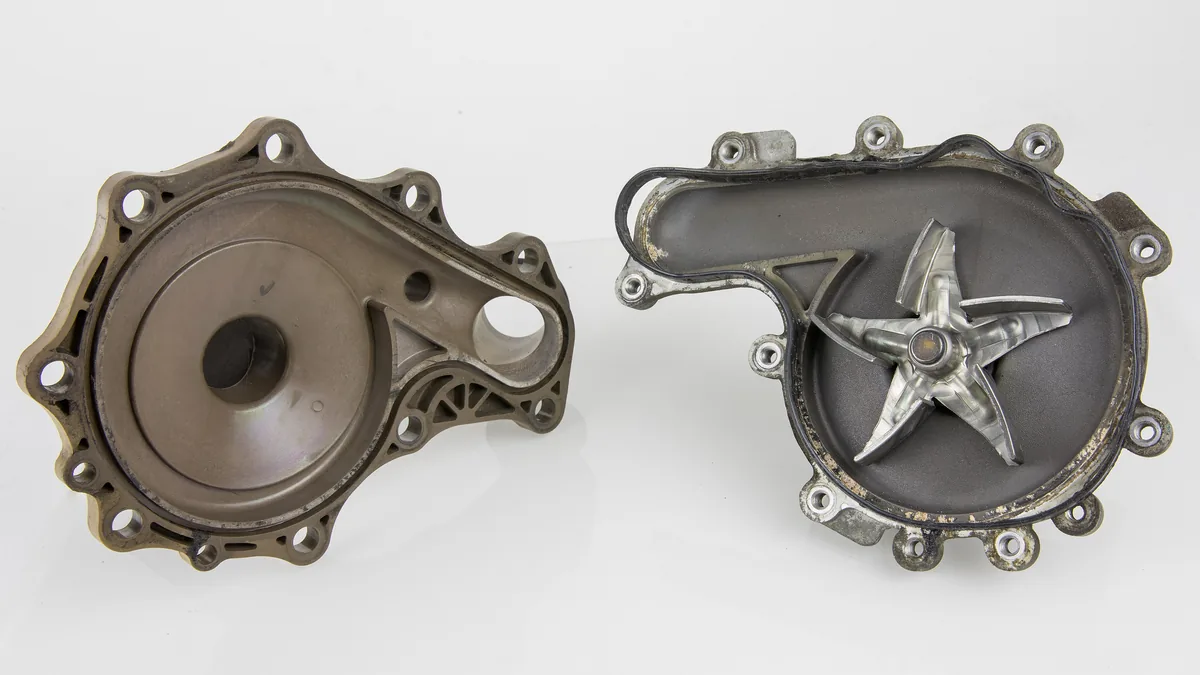 A water pump taken apart, with its cover on the left and the star shaped impeller on the right