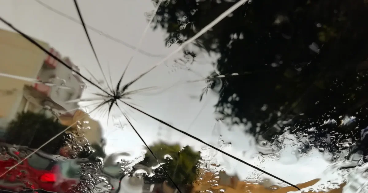 Looking out through a car windshield with a star shaped break and long cracks running from it